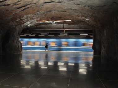 Hinter einem Tunnel fährt sehr schnell eine U-Bahn vorbei.