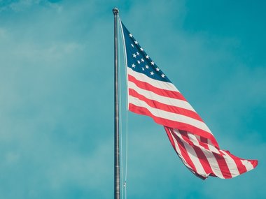 Die amerikanische Flagge vor blauem Himmel.