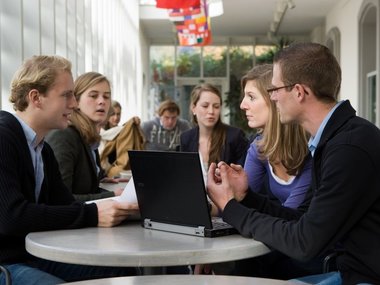 Eine Gruppe von Stunden der WHU - Otto Beisheim School of Management sitzen an einem Tisch und führen Konversation