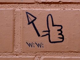 Die Abkürzung WiWi für Wirtschaftswissenschaften an einer Mauer mit einem Daumen-Hoch als Like-Zeichen.