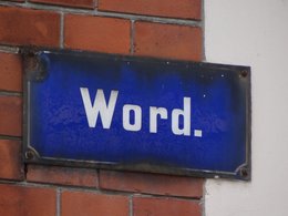 Ein altes blaues Straßenschild mit dem Wort -word- in weißer Schrift.