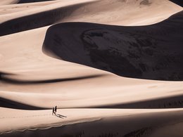 Ein Paar geht in einer Wüstenlandschaft mit Tälern spazieren.