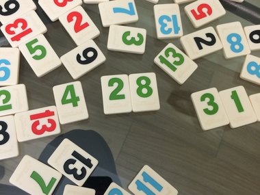 Zahlensteine mit farbigen Zahlen liegen durcheinander.