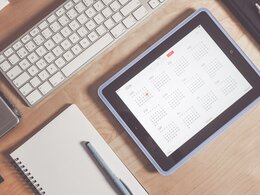 Zeiterfassung: Das Bild zeigt einen Arbeitsplatz an dem auf einem Tablet ein Kalender geöffnet ist.